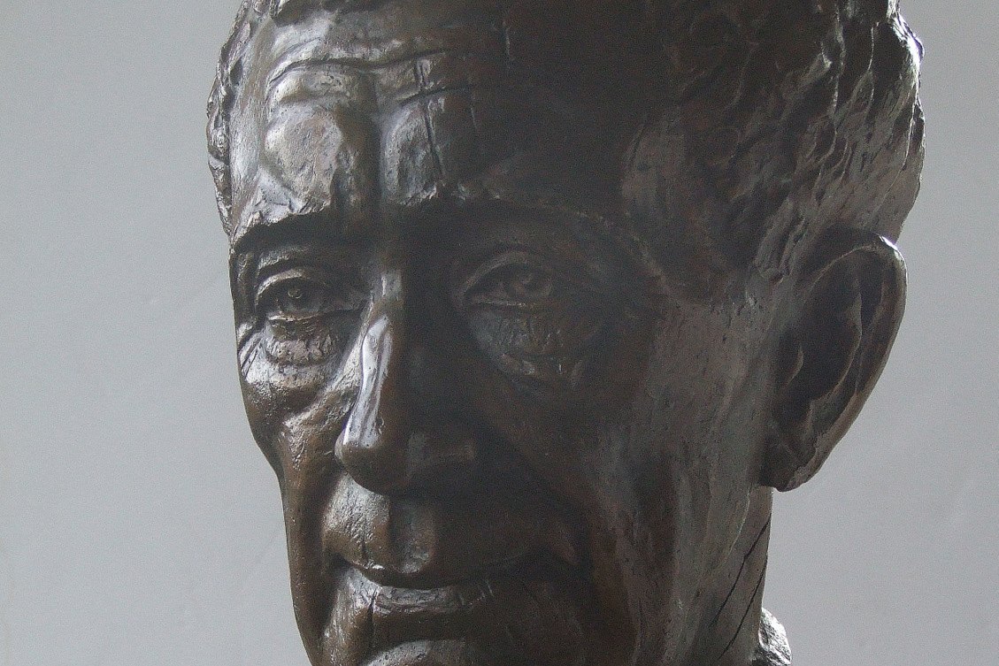 Busto de bronce del escritor alemán Ernst Jünger, con expresión seria e iluminación cálida