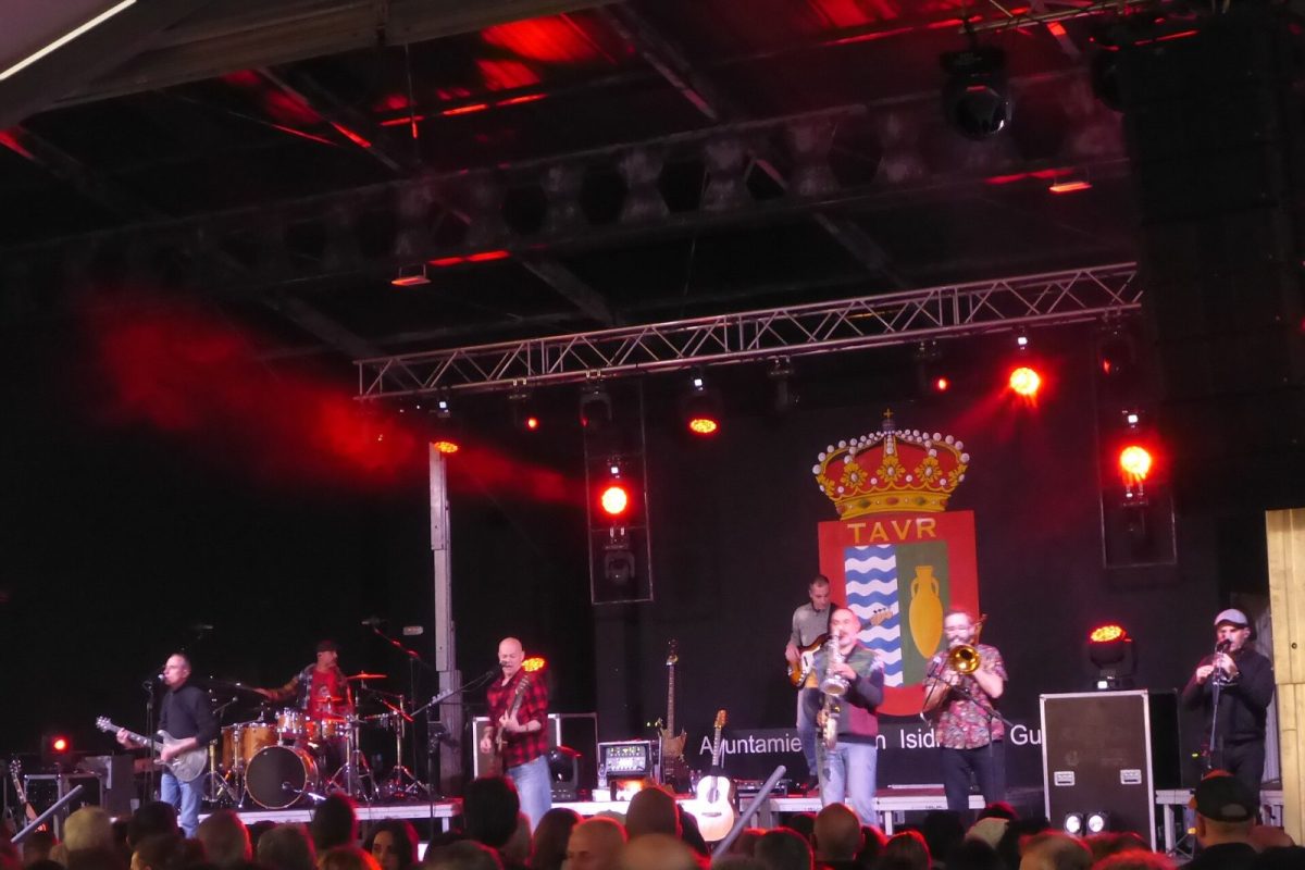 La banda Celtas Cortos tocando en un escenario iluminado en rojo ante el público de un concierto