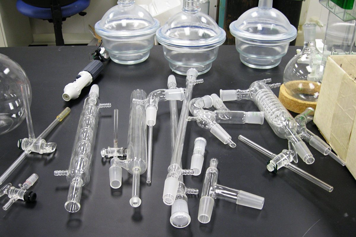 Mesa de laboratorio con matraces, tubos y material de vidrio de química dispuestos para un experimento