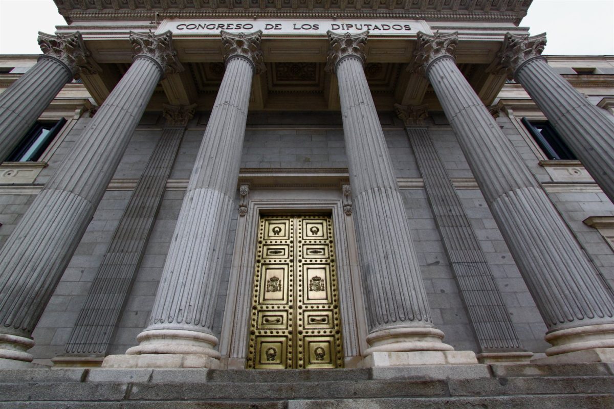 Columnas clásicas y puerta dorada de la fachada del Congreso de los Diputados en Madrid, vistas en contrapicado
