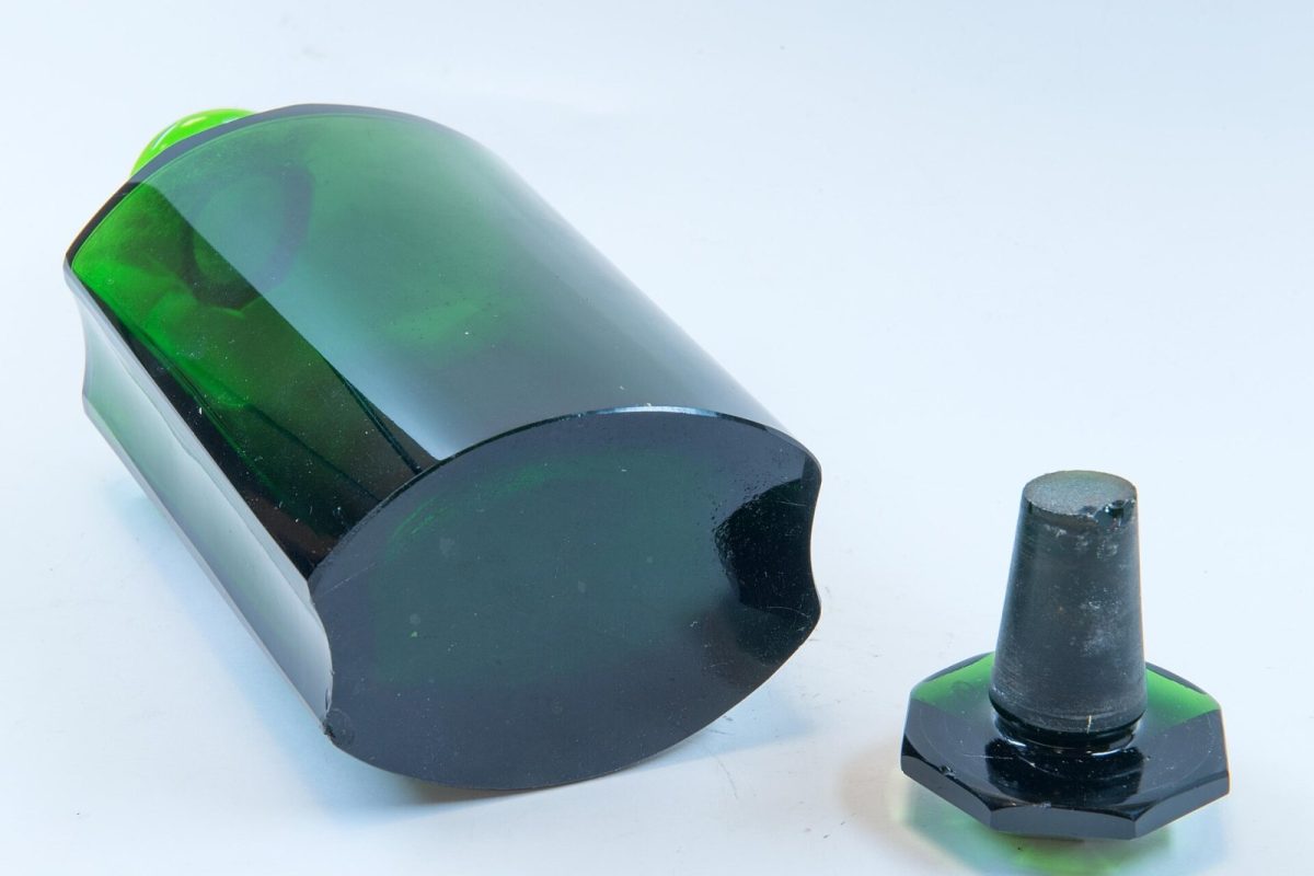 Frasco de vidrio verde de farmacia de estilo modernista, con su tapón, fotografiado en estudio sobre fondo blanco