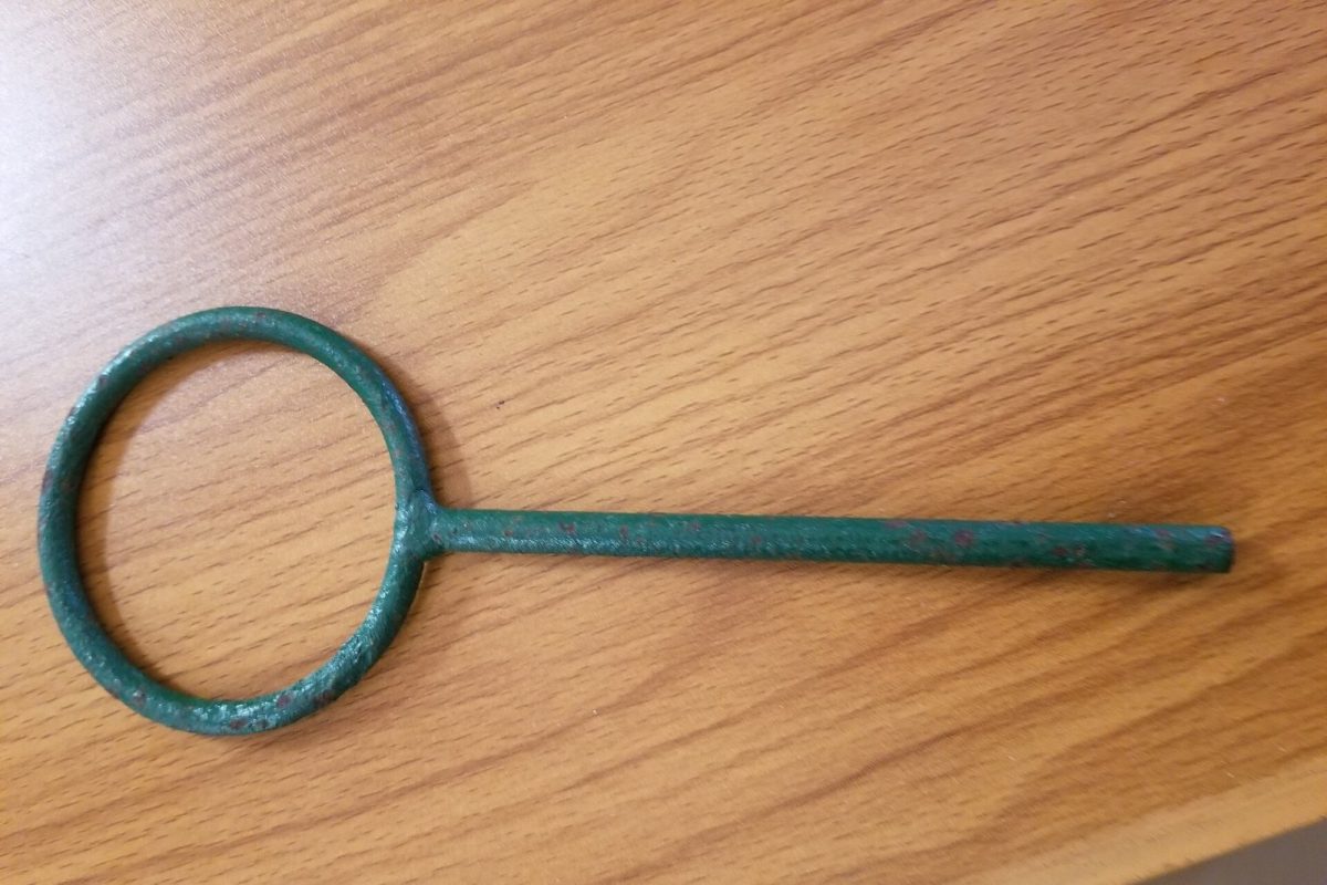 Primer plano de una anilla de sujeción metálica de color verde, utensilio de laboratorio usado para sostener matraces sobre un soporte