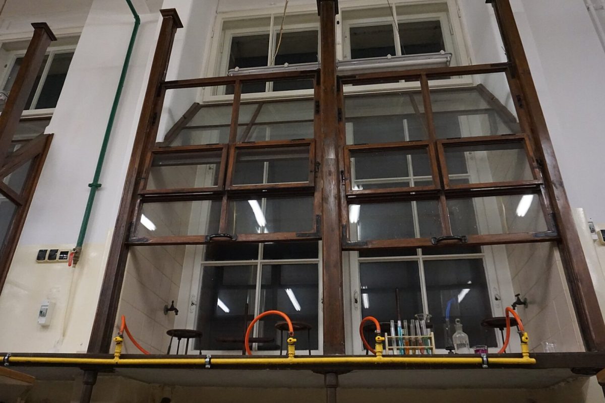 Vitrina de gases de madera de estilo antiguo (1904) en un laboratorio universitario, con grifos de gas y una gradilla de tubos de ensayo