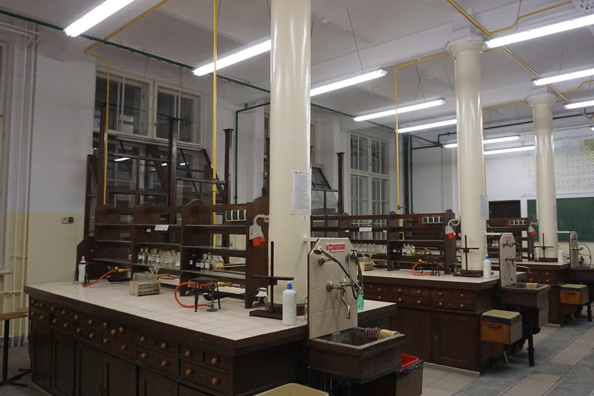 Antiguo laboratorio universitario de química con bancadas de madera, columnas y vitrinas de gases