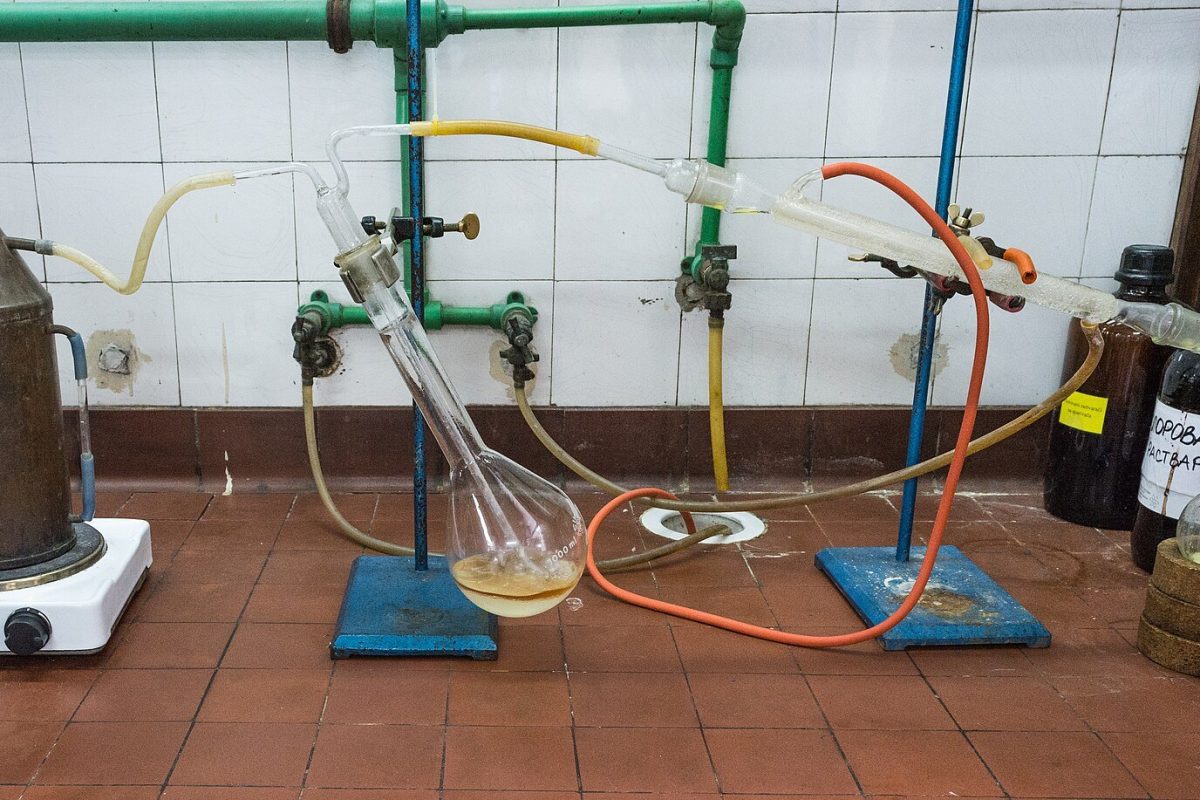 Equipo de destilación de laboratorio con matraz de calentamiento, refrigerante y mangueras conectadas a la instalación