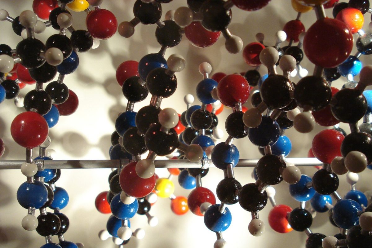 Primer plano de un gran modelo molecular tridimensional con esferas de colores rojo, negro, azul y blanco entrelazadas