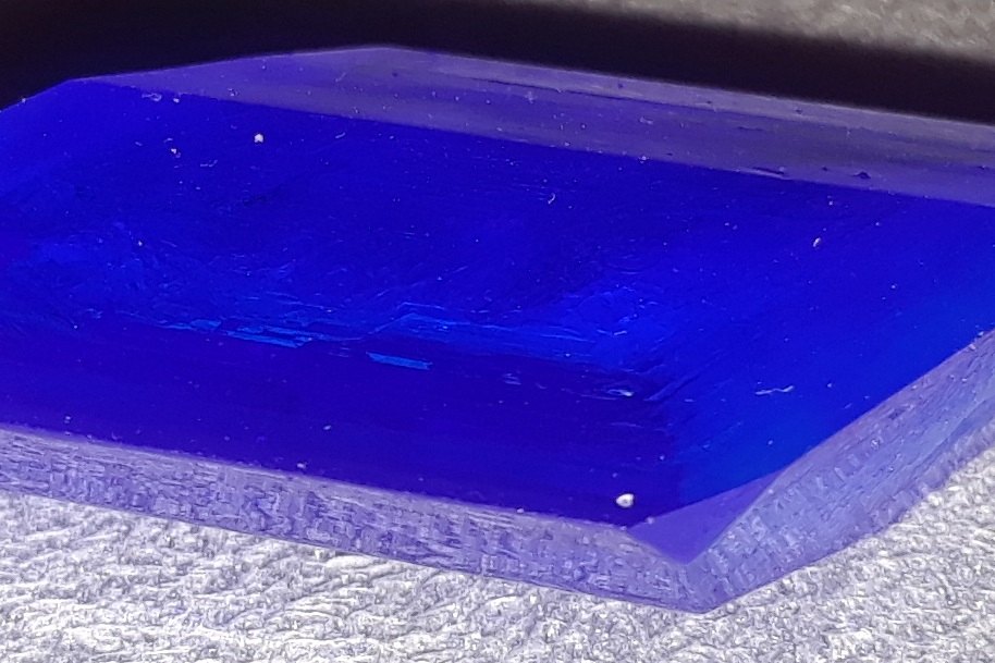 Primer plano macro de un monocristal de color azul intenso de sulfato de cobre (vitriolo azul)