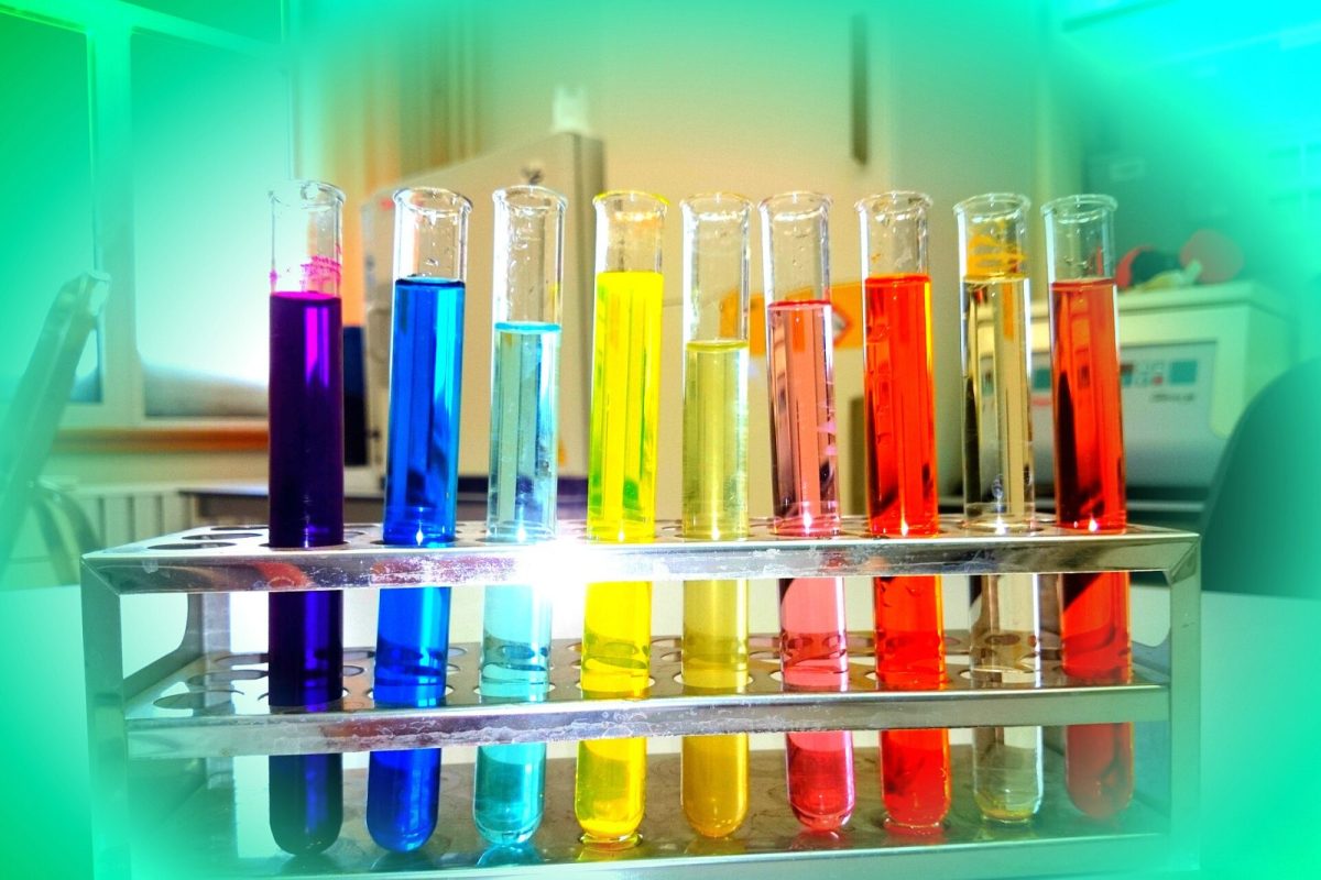 Gradilla con tubos de ensayo llenos de disoluciones químicas de distintos colores en un laboratorio