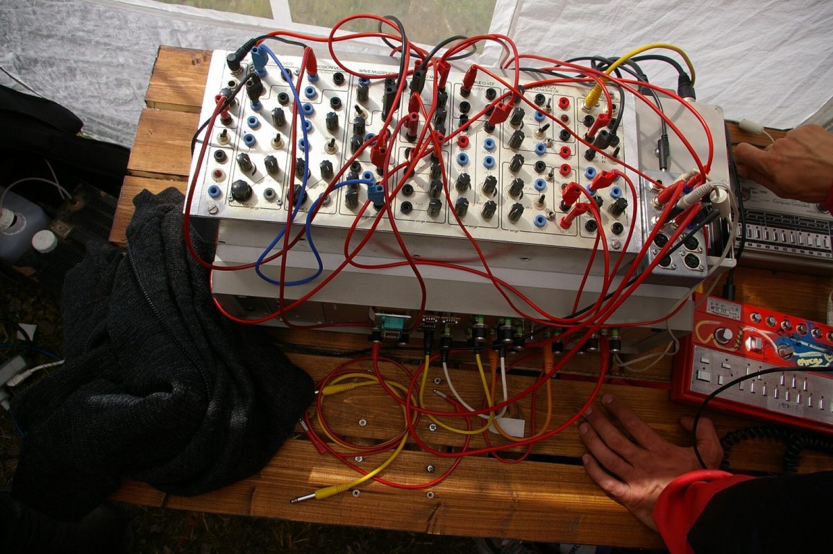Primer plano de un sintetizador modular analógico con múltiples cables de parcheo de colores