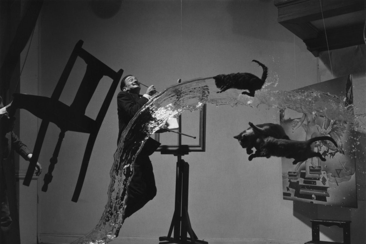 Salvador Dalí suspendido en el aire junto a gatos, agua y muebles en pleno vuelo, en la célebre fotografía surrealista de Philippe Halsman