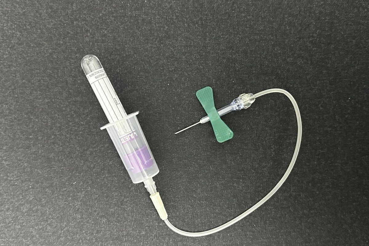 Aguja tipo mariposa conectada a un tubo de recolección de muestra sanguínea
