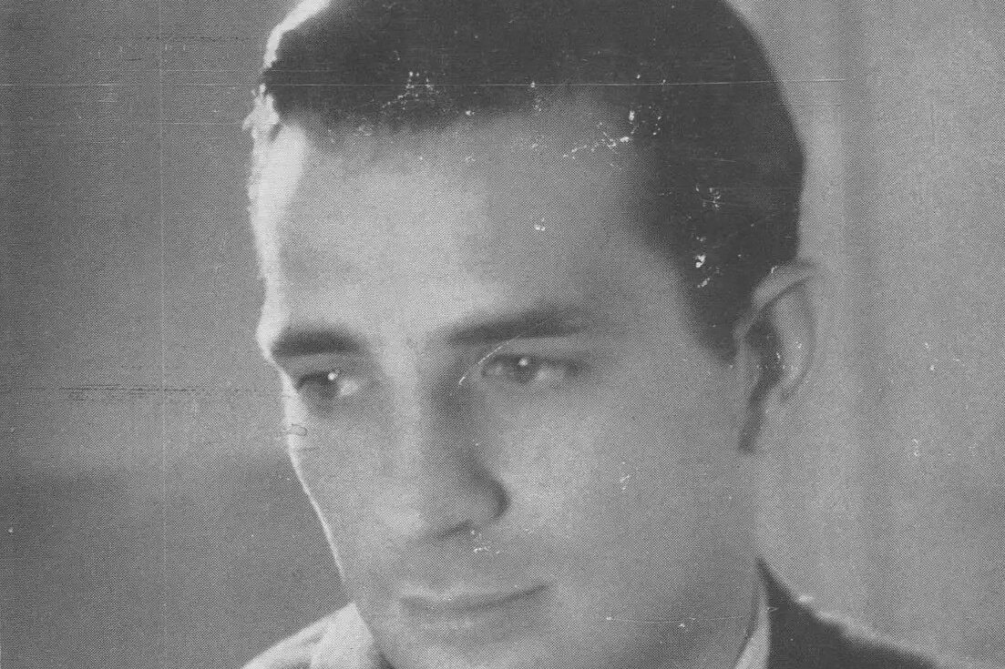 Fotografía en blanco y negro de un joven Jack Kerouac vestido con traje y corbata, mirando hacia un lado