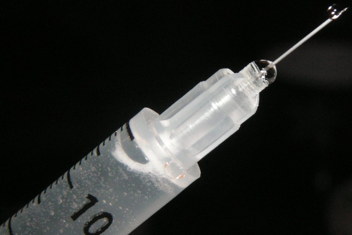 Aguja y jeringuilla médica en primer plano sobre fondo negro