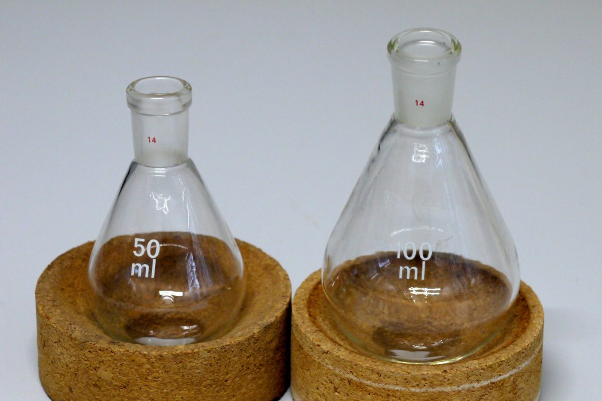 Dos matraces cónicos de vidrio de laboratorio apoyados en anillos de corcho