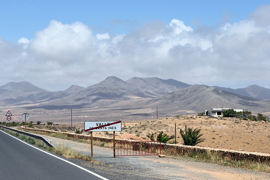 Carretera solitaria hacia el Valle de Santa Inés con montañas volcánicas de Fuerteventura al fondo