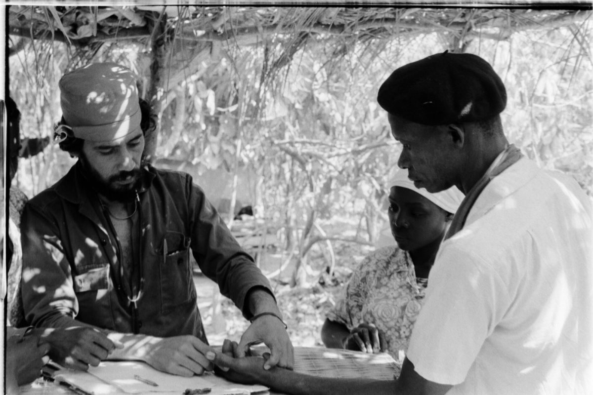Fotografía histórica en blanco y negro de un médico examinando la mano de un paciente durante una consulta médica