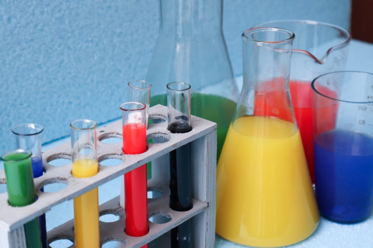 Tubos de ensayo, matraces y vasos de precipitados con líquidos de distintos colores en un laboratorio de química