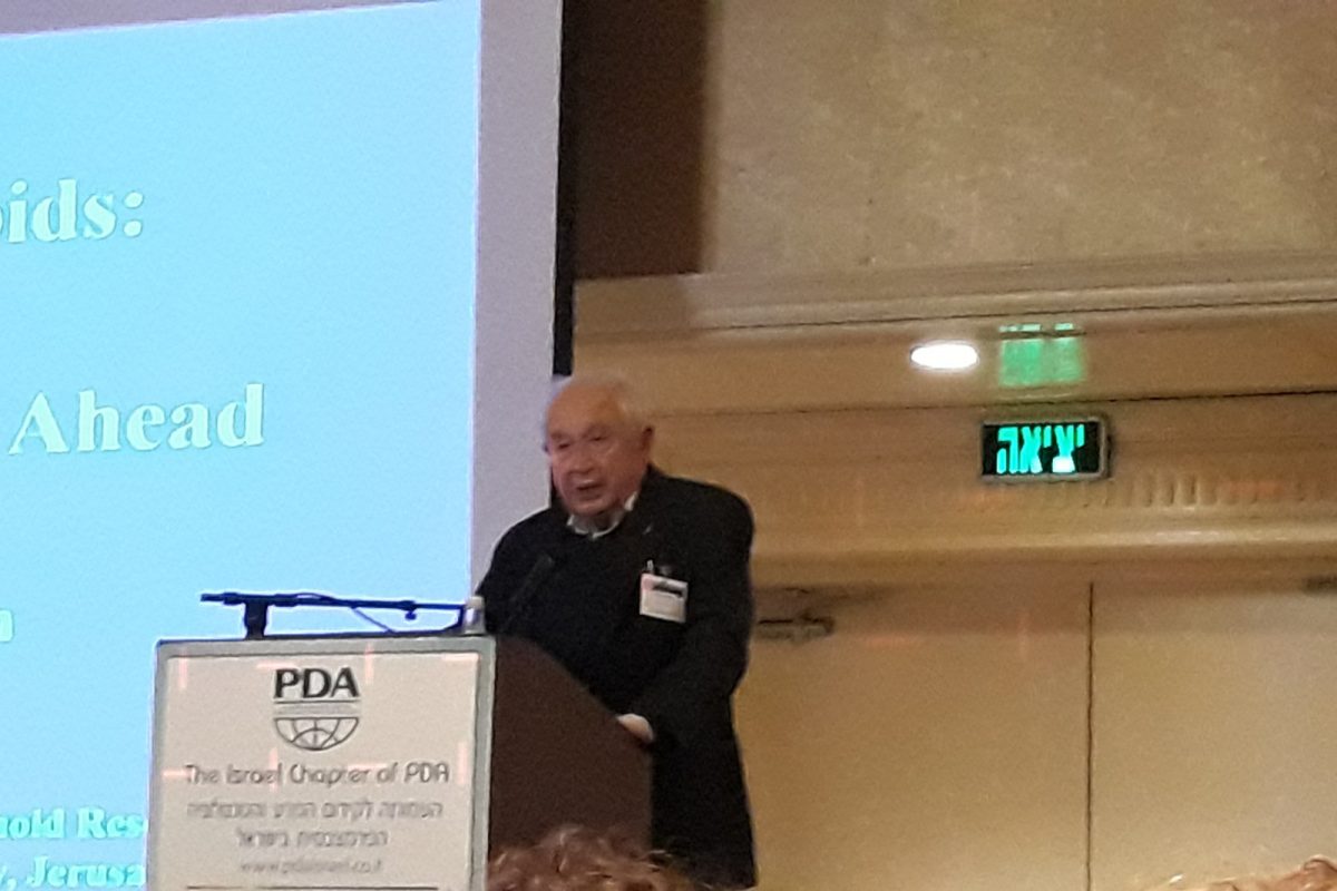 El científico Raphael Mechoulam impartiendo una conferencia sobre cannabinoides ante un atril