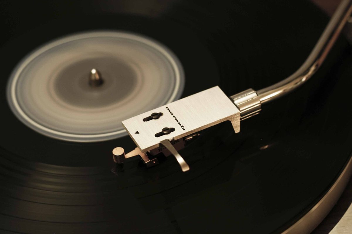 Primer plano del cabezal y la aguja de un tocadiscos de vinilo girando, evocando la cultura musical analógica