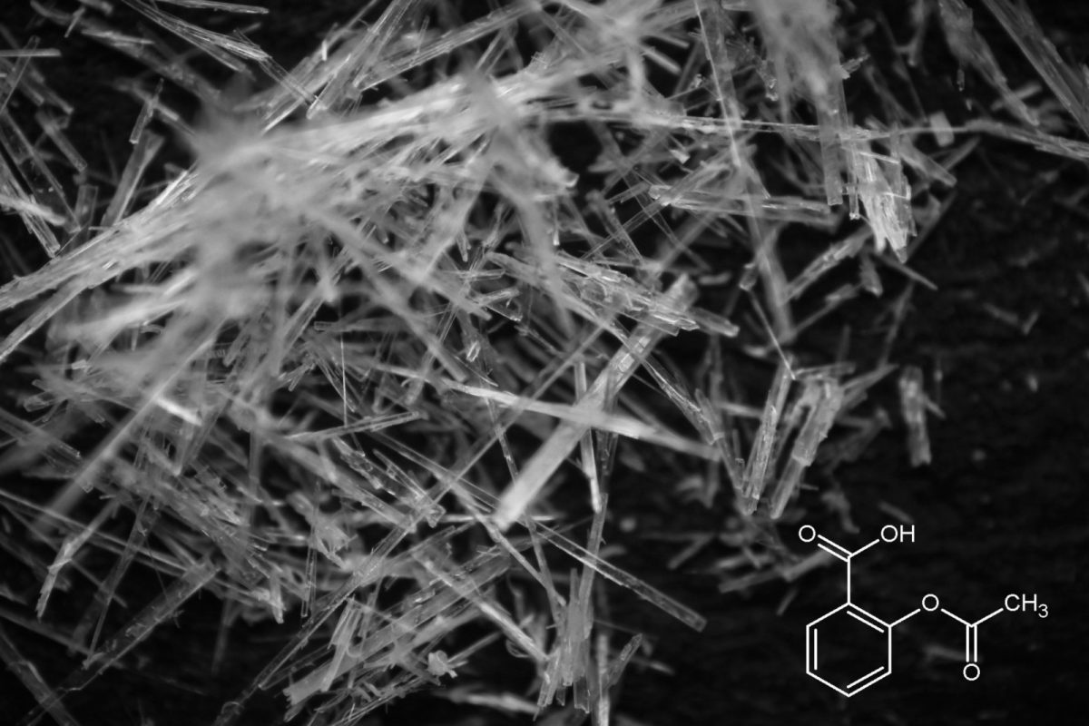 Fotografía macro en blanco y negro de cristales de aspirina junto a un diagrama de su estructura molecular