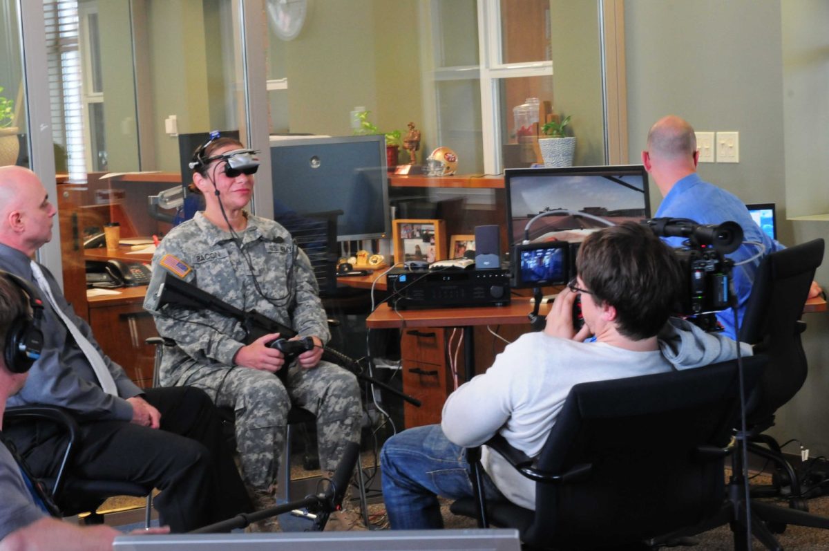 Una militar prueba un sistema de terapia de realidad virtual para el tratamiento del TEPT, supervisada por personal en un entorno clínico.