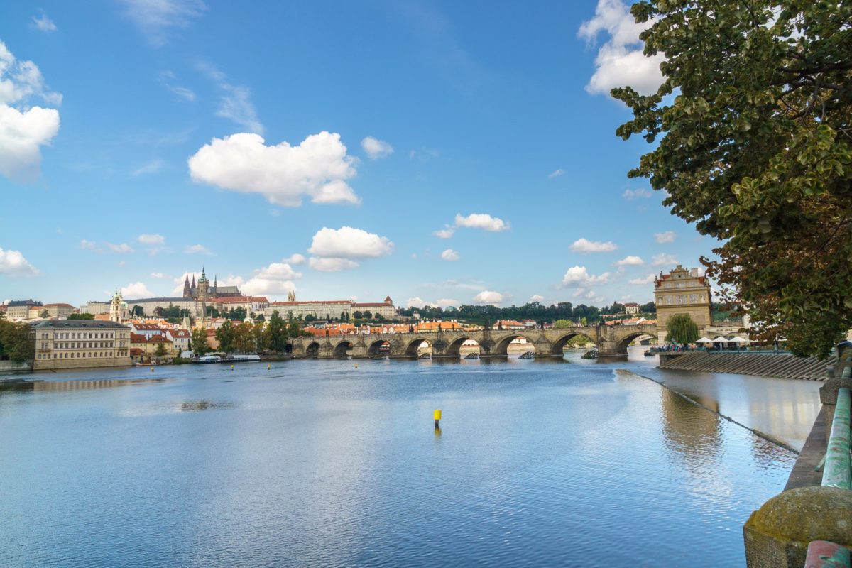 Vista del río Moldava a su paso por Praga, con el Puente de Carlos y el castillo al fondo