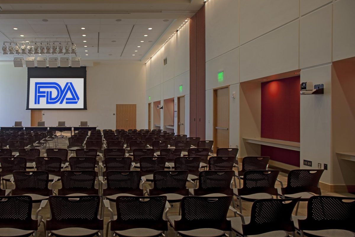 Sala de actos vacía con filas de sillas y el logotipo de la FDA proyectado en la pantalla