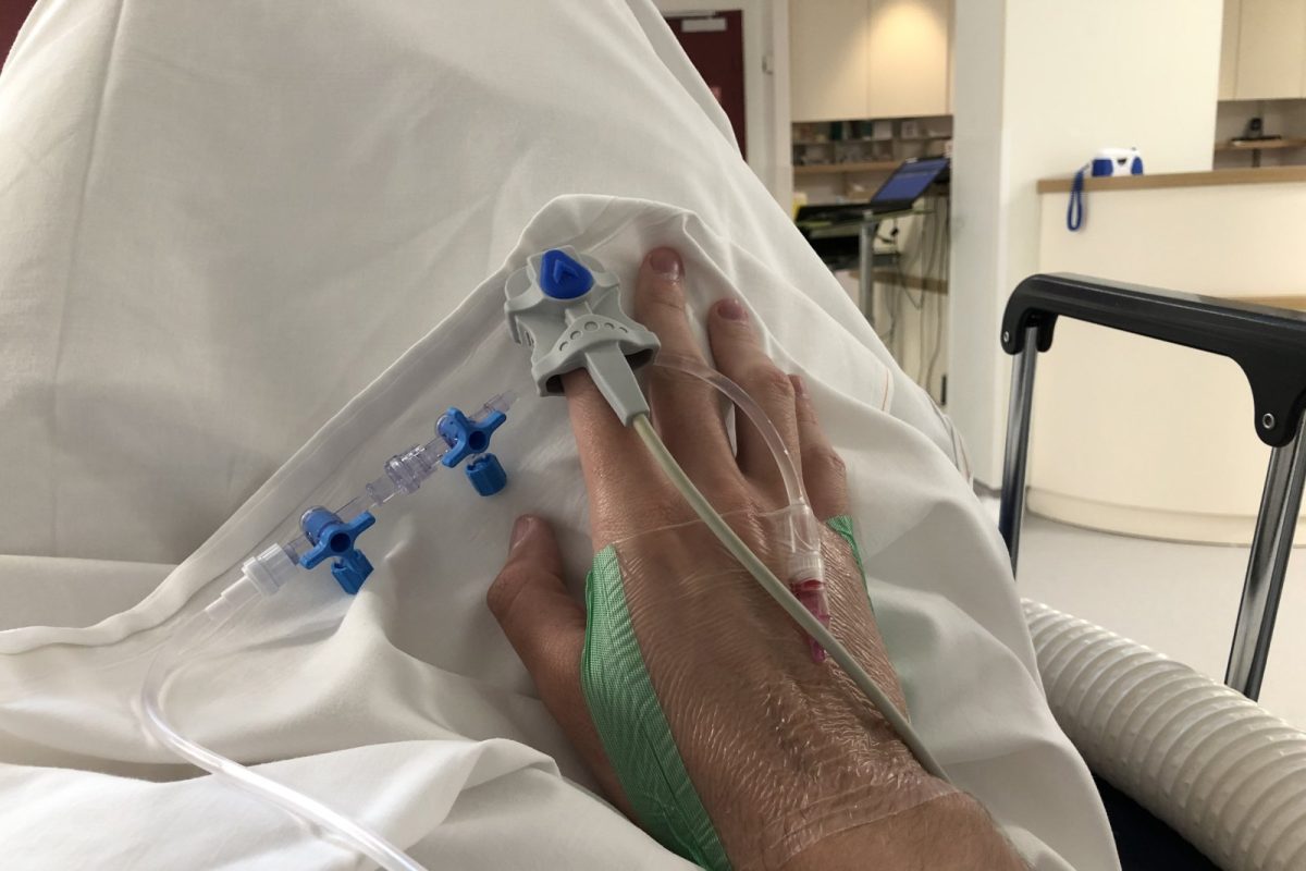 Mano de una persona ingresada con una cánula intravenosa conectada a un sistema de perfusión