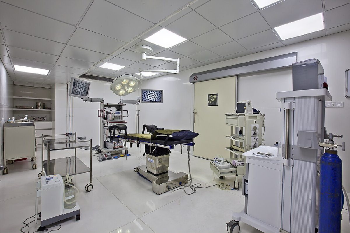Quirófano vacío con mesa de operaciones, lámparas quirúrgicas, equipo de anestesia y monitores