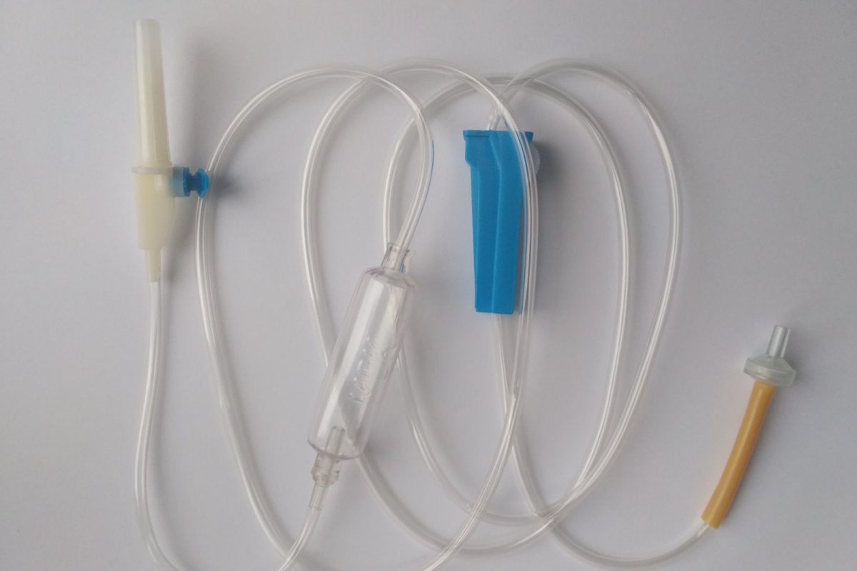 Equipo de gotero para infusión intravenosa desplegado sobre fondo blanco