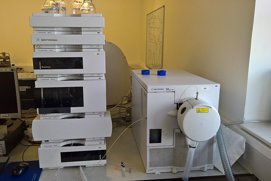 Equipo de cromatografía líquida conectado a un espectrómetro de masas sobre una mesa de laboratorio