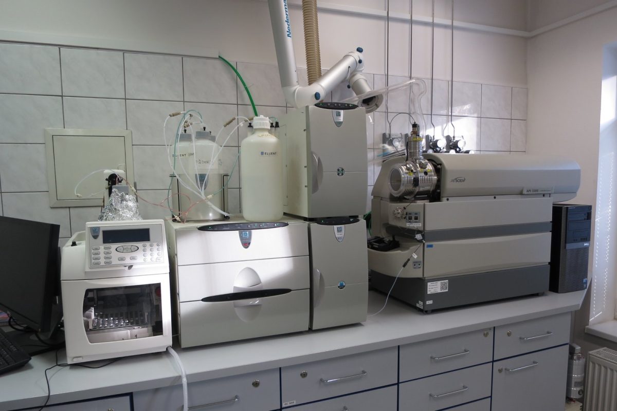 Equipo de análisis instrumental sobre una encimera de laboratorio: un cromátografo iónico conectado a un espectrómetro de masas, con viales y tubos de conexión