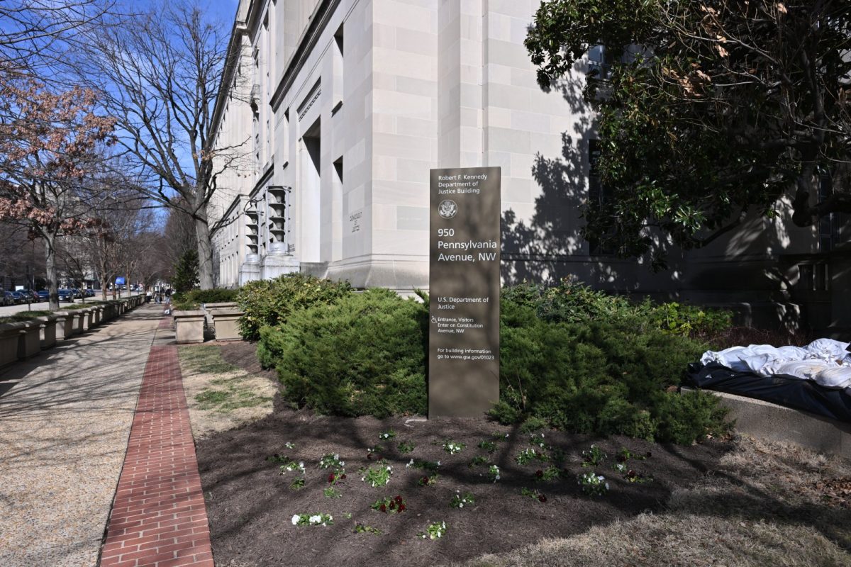 Fachada de piedra clara del edificio Robert F. Kennedy del Departamento de Justicia en Washington, con un cartel identificativo entre arbustos