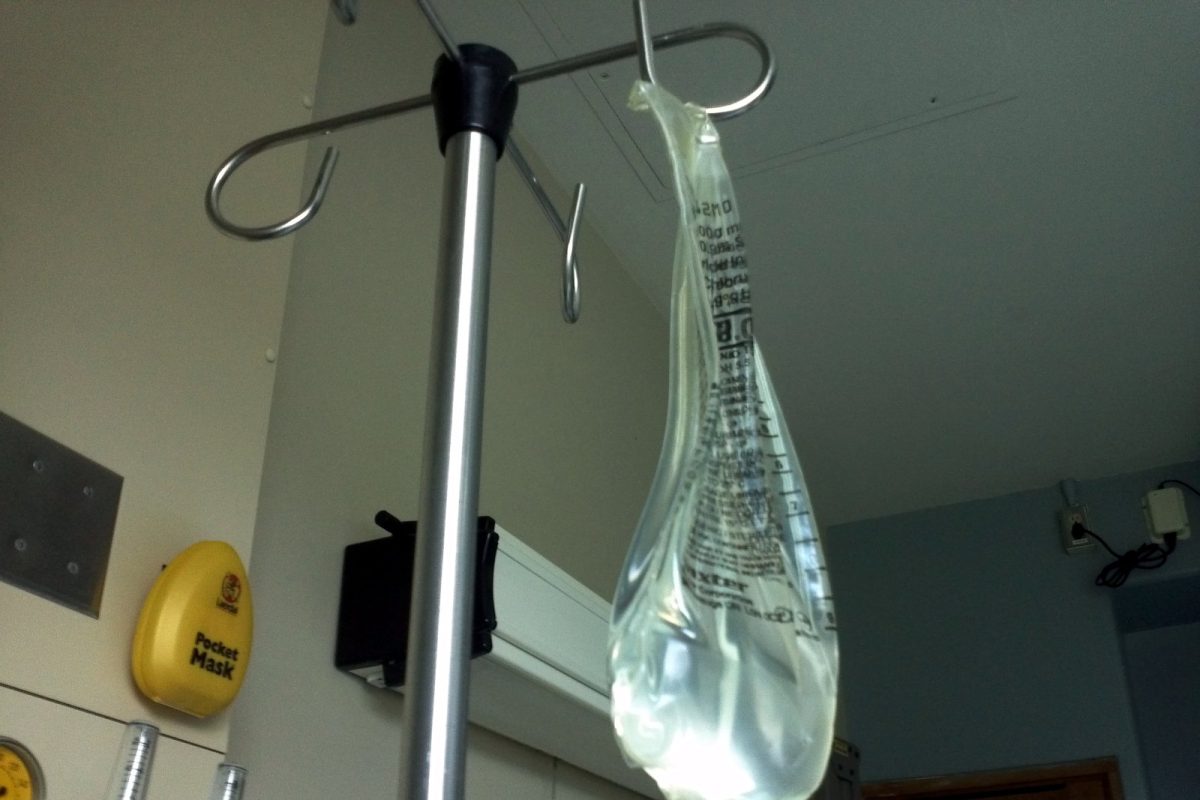 Bolsa de suero colgada de un soporte de gotero en una sala clínica